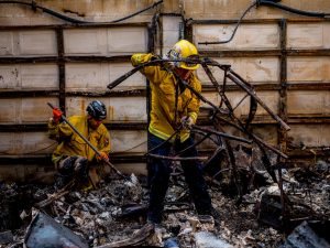 Firefighters rummaging through debris in the aftermath of the Camp Fire in Paradise, California. 
Photo by Zackary Canepari (Courtesy of Netflix)