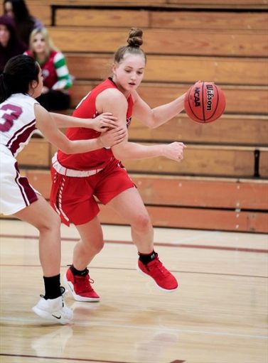 Stella Rollo moves up the court with the ball in a game for Denver East High School in Denver, Colo.