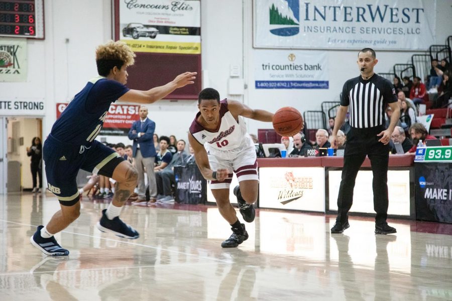 Chico State Guard Joshua Curls drives with the ball in a basketball game.