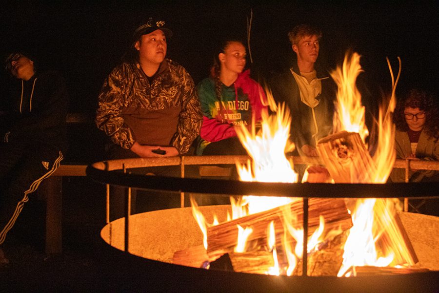 Students gathered around a camp fire.