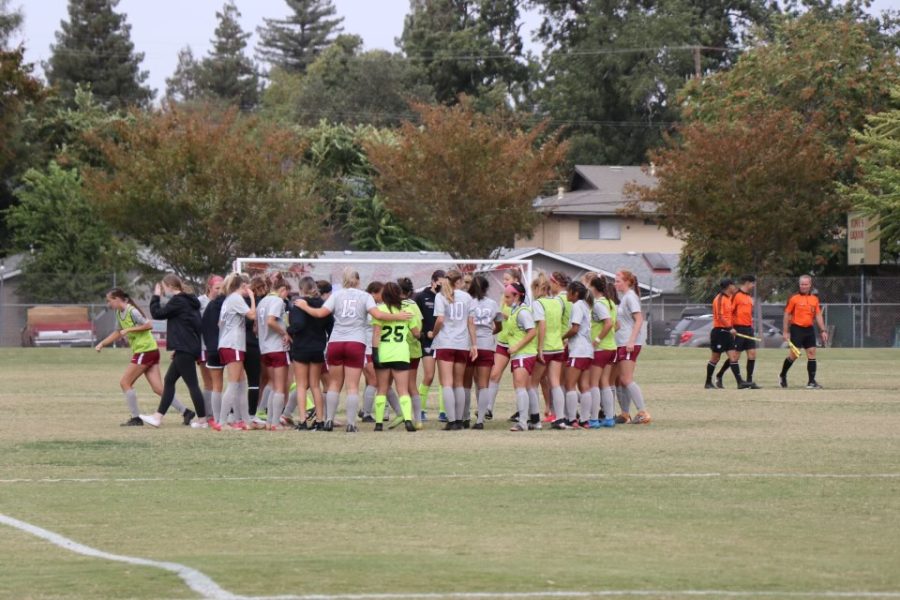 Womens soccer team huddled together. Photo Credit: Mason Tovani
