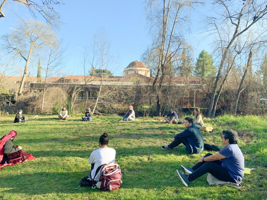 Students+sitting+in+a+circle+on+the+lawn.