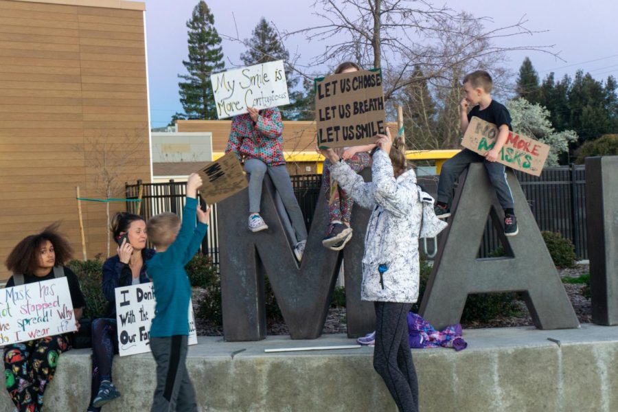 Parents and children held signs in protest of the mask mandate outside of the Marigold Elementary School multipurpose room on Feb. 16.