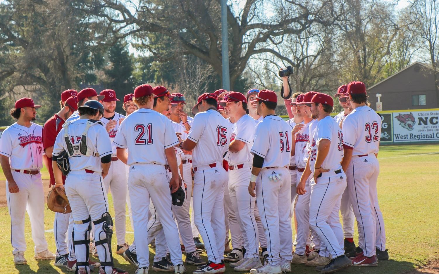 The 2022 Chico State Baseball team gathering around the right field line before the game.