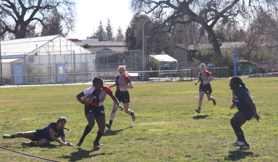 Francine Nshimirimana breaking through tackles, running the ball down the line of touch.