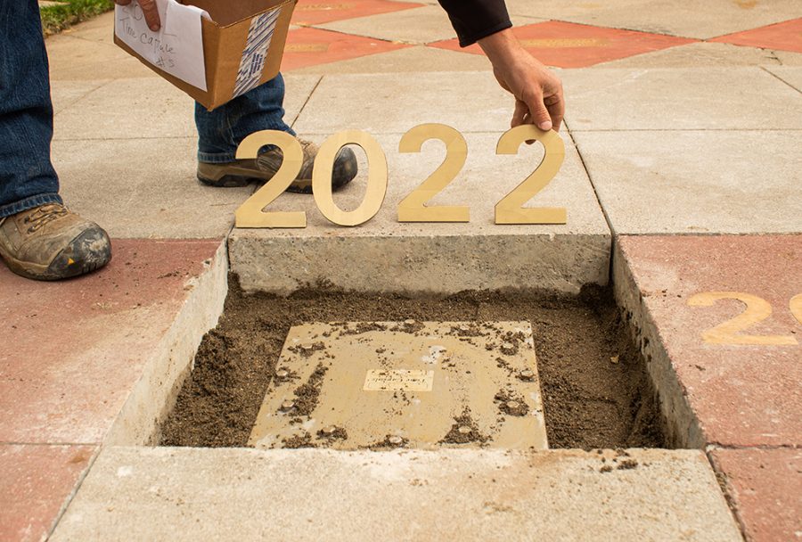 A hole in the concrete in front of Kendall Hall on Chico State Campus with a time capsule being buried.