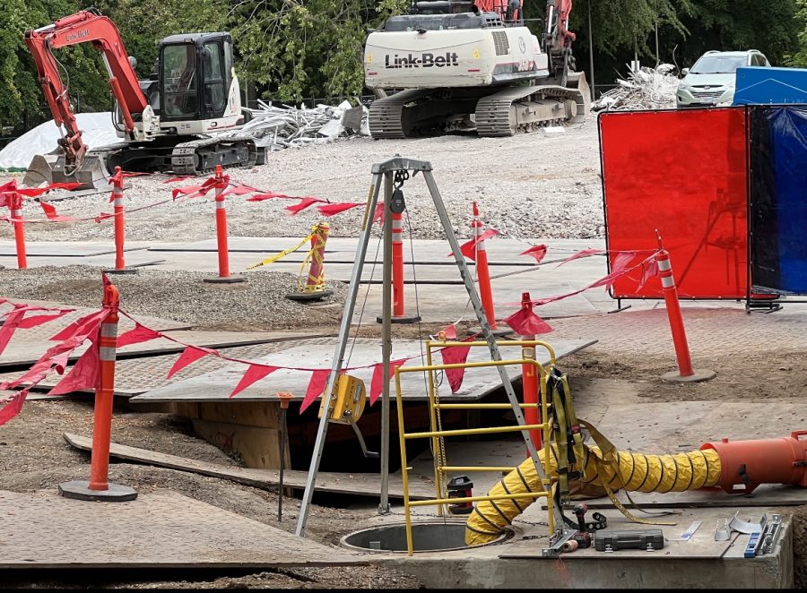construction site with orange flags and an open hole in the ground 