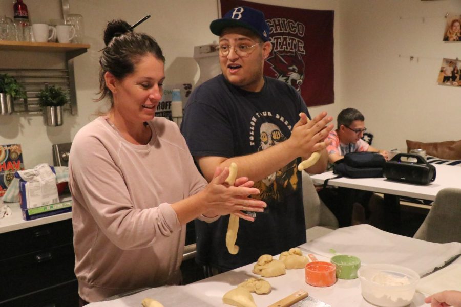 Hillel director and student rolling challah dough to prepare for baking