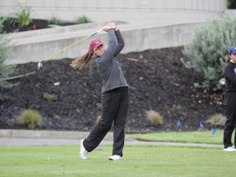 At the top of the tee box, Taylor Stewart hits her golf shot into the fairway with her driver. Photo captured by Chico State Sports Information.