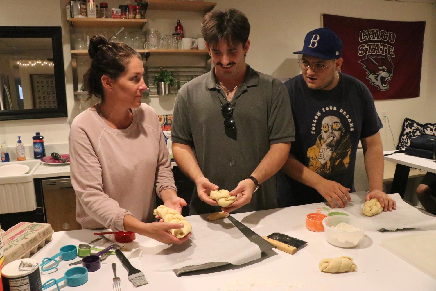 three people discussing the perfect challah braiding technique while braiding challah