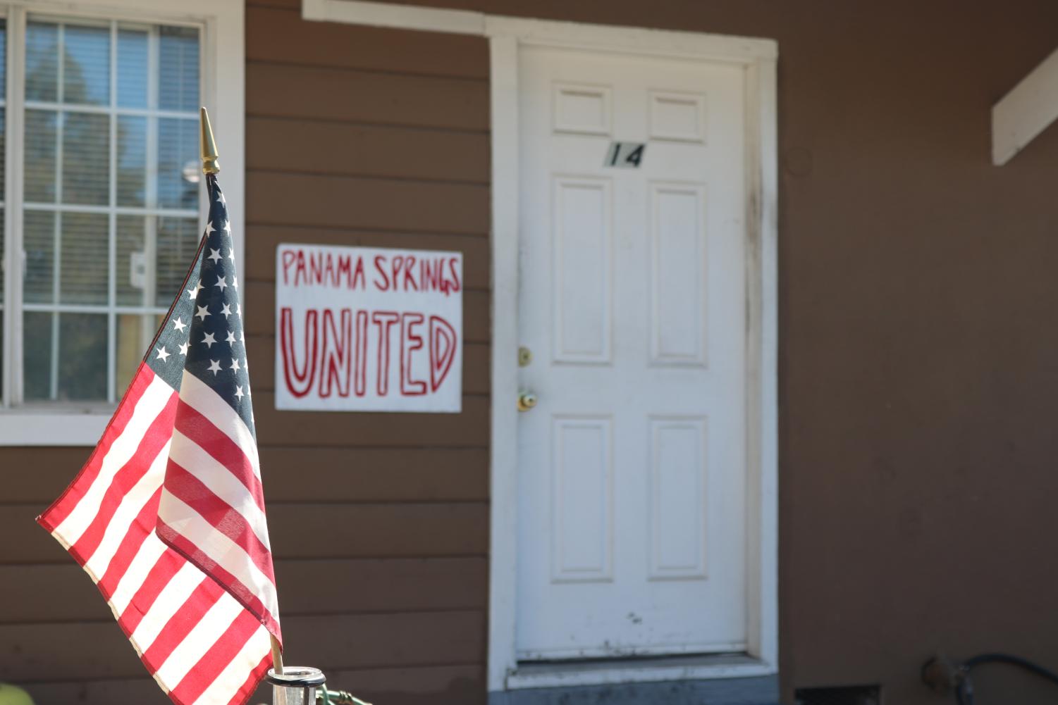 American flag and sign on wall reading "Panama Springs United"