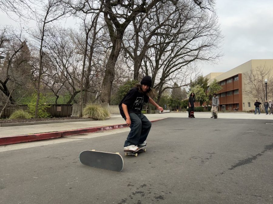 Teenager preparing to ollie over a skate board on its side. Photo is taken outside and the teen is on asphalt.