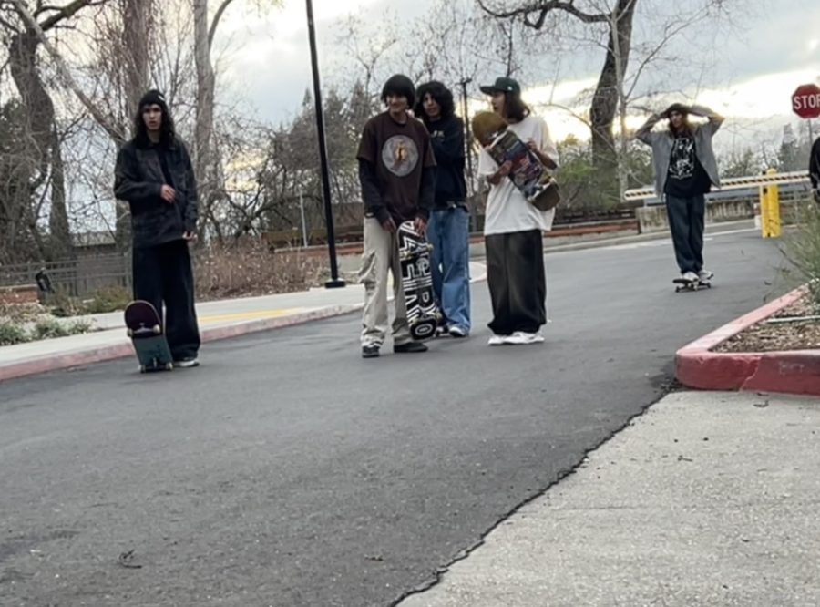 Five teenagers with skateboards on asphalt outside