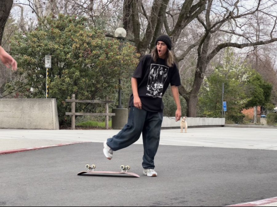 Teenage boy in all black outside with a skateboard