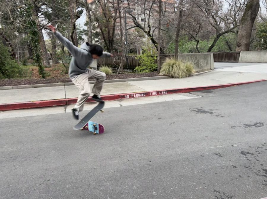 teen boy ollies over a skateboard