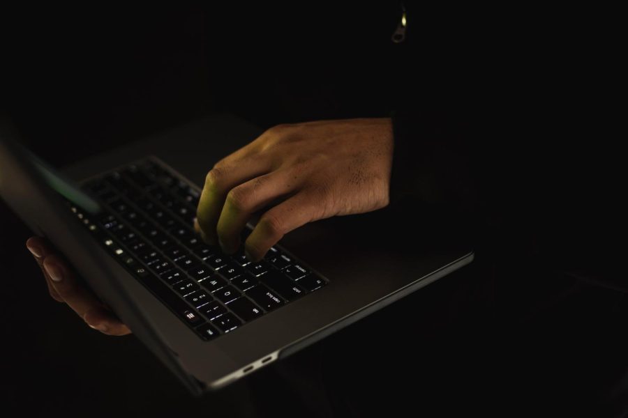Hand typing on a laptop keyboard