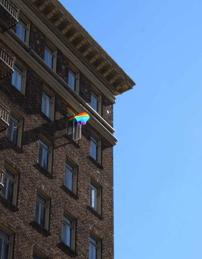 A pride flag flying out of a buildings window in San Francisco.