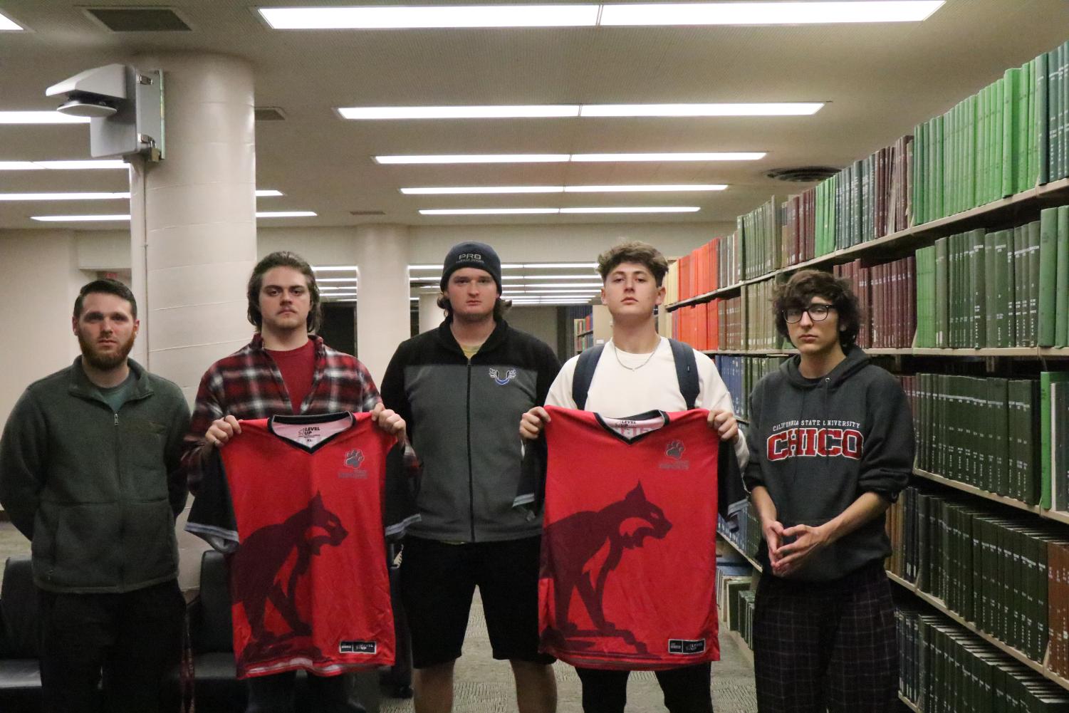 Wildcat esports team members stand with jerseys. Photographed by Wyatt Alpert March 22.