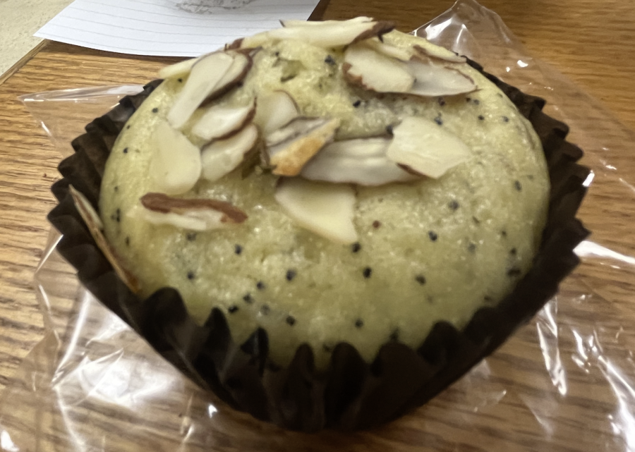 Small black poppyseeds can be seen against the light beige color of Cafe Muse's almond poppyseed muffin.