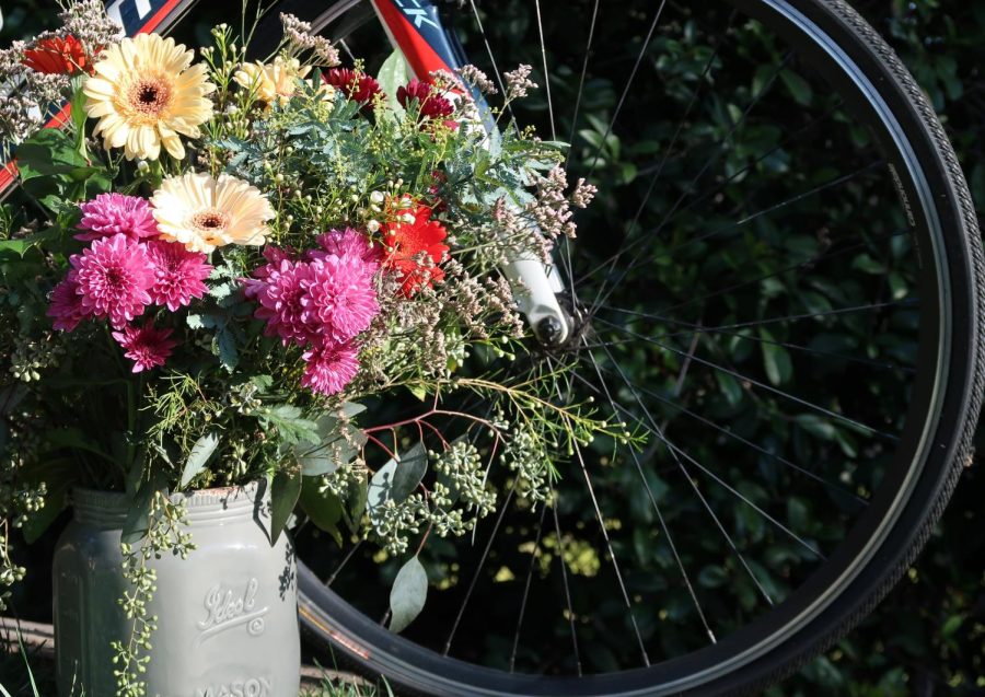 a flower boquet sits in front of a bicycle wheel