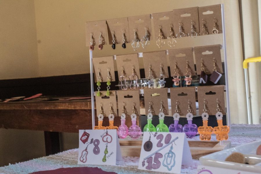 Three rows of earrings hang from a white display rack. There are 16 pairs of earrings on display.
