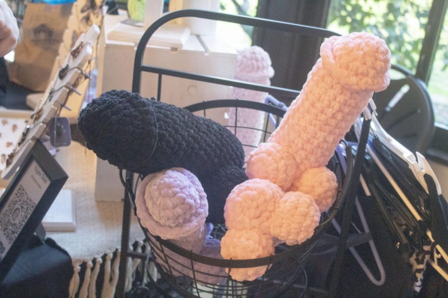 Two large crocheted penises, one black and the other pink, it on top of slightly smaller crocheted cocks, one purple, the other pink with balls facing out.
