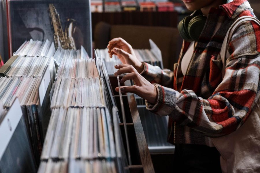 Hands flipping through rows of vinyl records.