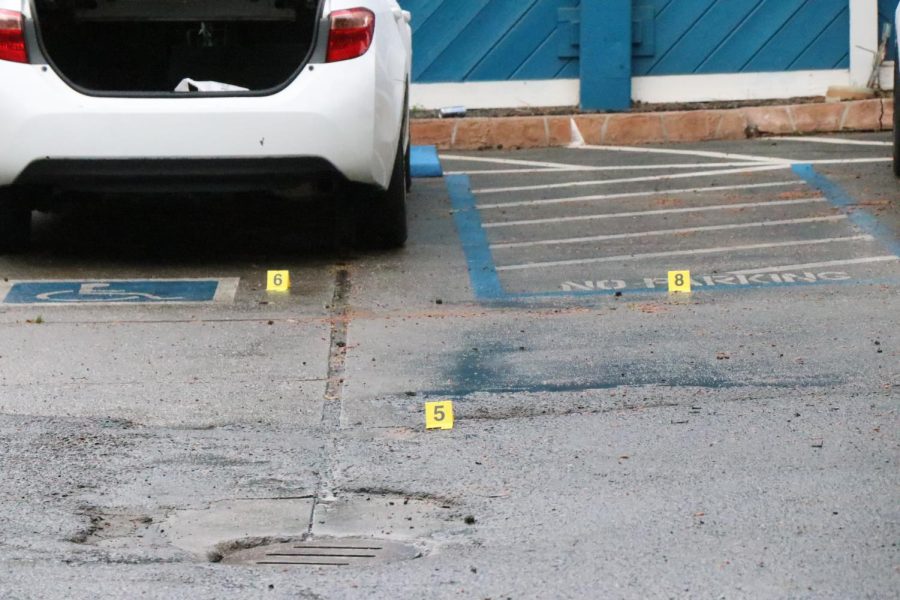 Bullet hole in rear bumper along with the numbers 6,5 and 8 evidence markers.