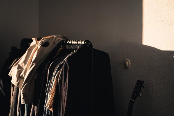 Photo of a clothes rack in the corner of a room next to a guitar. Taken Dec. 13, 2021 by Erik Schereder, courtesy of Pexels.