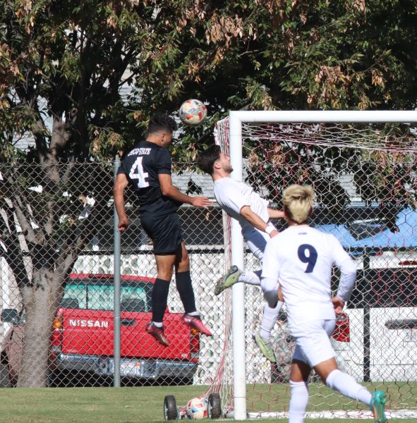 Bryan Manriquez (black jersey) goes for a header against Cal State Monterey Bay