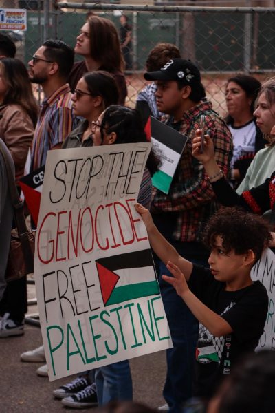 Child holding sign reading STOP THE GENOCIDE FREE PALESTINE at pro-Palestine protest in Chico. Photo taken Nov. 4 Milca Elvira Chacon.