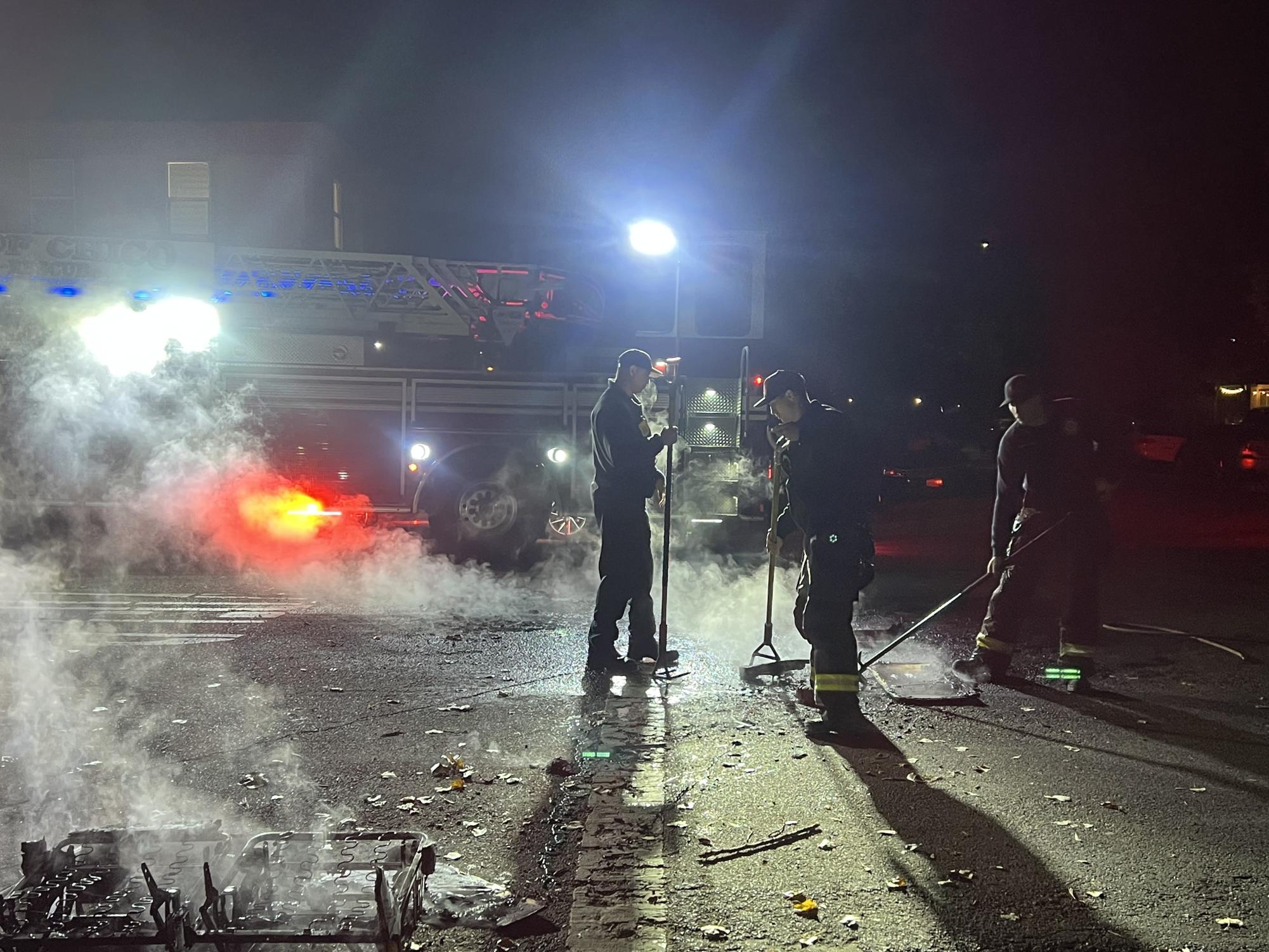 Three firemen rake the remains of a soggy couch fire. Photo taken Nov. 27 by Molly Myers.