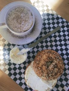 An all seed bagel and an orange drop cappuccino at Bidwell Perk on Dec. 12, 2023. The orange drop cappuccino is on their signatures menu.