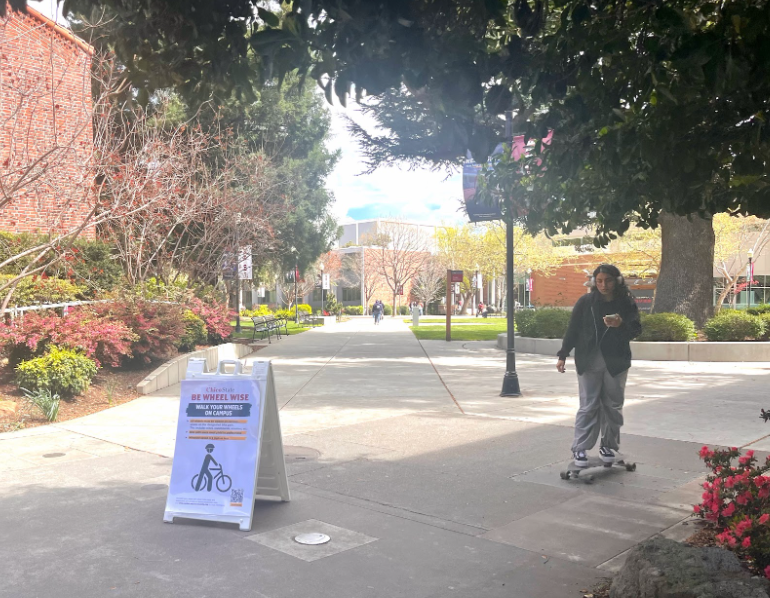 Student+skateboarding+past+the+new+%E2%80%9CBe+wheel+wise%E2%80%9D+signs+on+campus+near+Kendall+Hall.+Taken+by+Jessica+Miller+on+March+28
