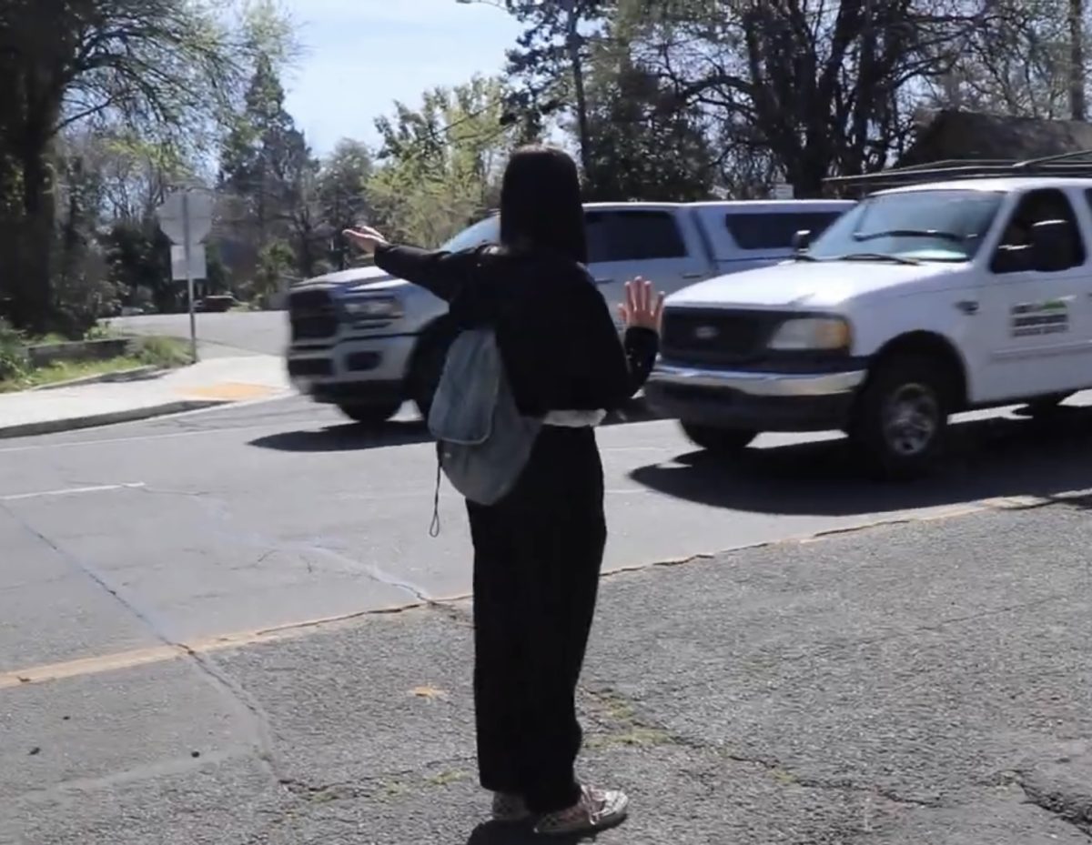 Molly Myers, managing editor of The Orion, sticks out her thumb on 9th street in Chico, California. Screenshot taken from The Orions video on hitchhiking. 
