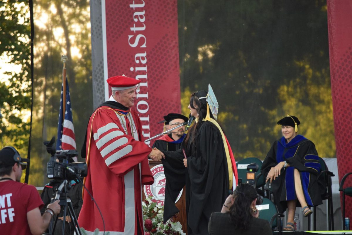 President Perez shaking the hand of Taylor Bisby as she receives her Masters degree. Taken by Jessica Miller on May 15