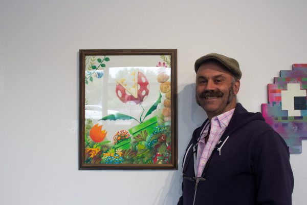 Artist Casey Fay next to his piece in the gallery on August 24 taken by Jenna McMahon. He also designed the flyer for the exhibit.