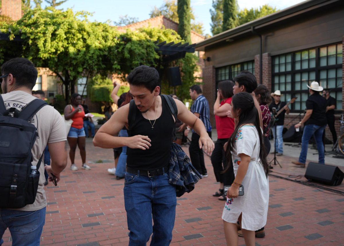 Sophomore student Juan Carlos Bermudez dances to banda music with his friend Thursday, Sep. 19, 2024 on Colusa Plaza at Chico State.