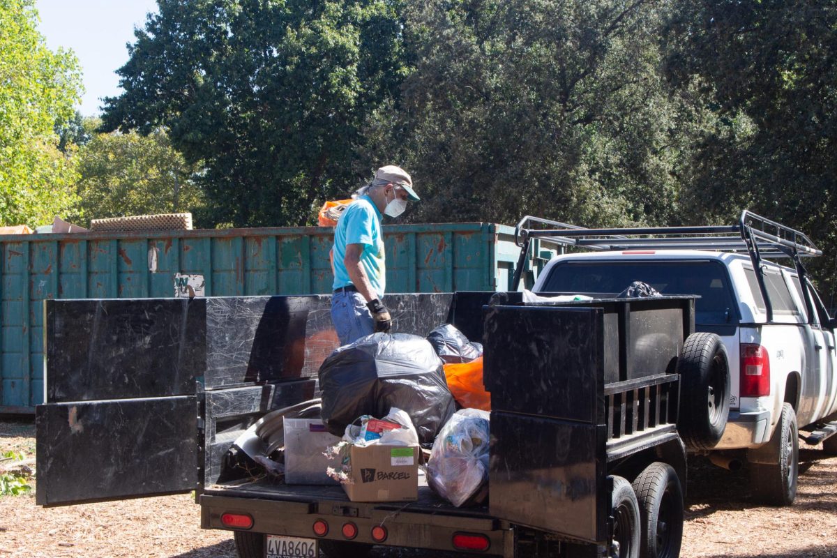 Volunteer Michael Stauffer helps unload trash from the trailer at Hooker Oak Park on Sept. 21. This was only one of multiple truck loads that Stauffer helped unload.