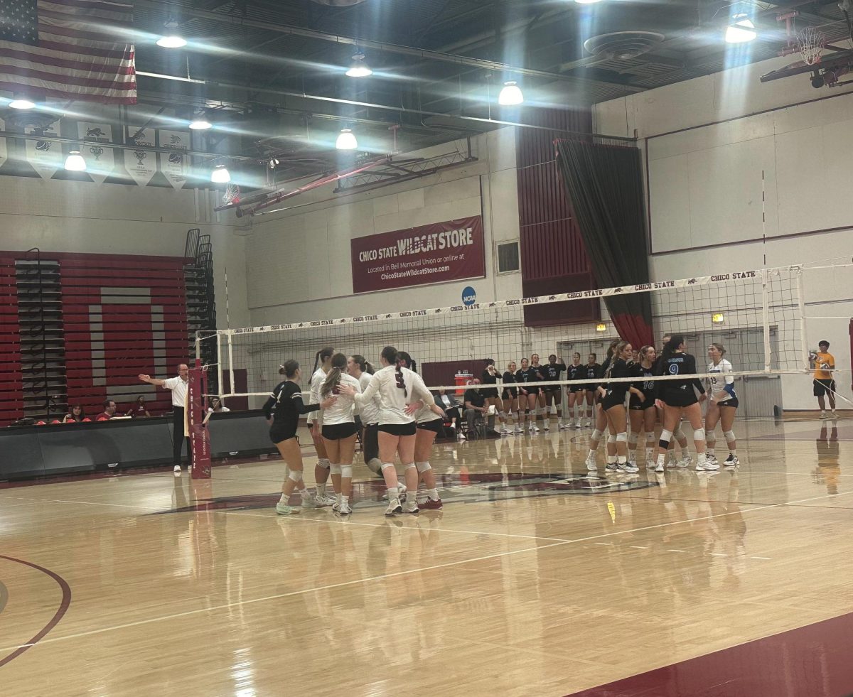 Chico State women’s volleyball team huddling after scoring a point in their game against Cal  State San Bernardino on Oct. 4 in Chico. Photo taken by Trevor Lee.
