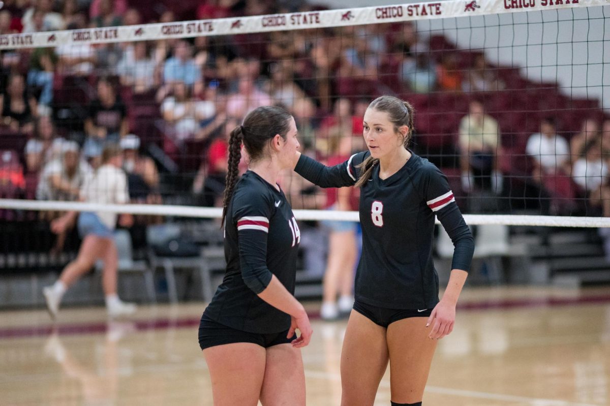 Claire Nordeen and Kassandra Nall discussing tactics prior to the third set. Taken by Aaron Draper on Oct. 5 