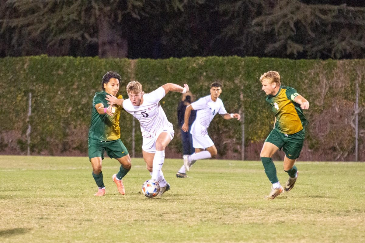 Wildcat Miles Rice dribbles through Cal Poly Pomona players on Oct. 25 taken by Jenna McMahon. He kept possession and was able to drive towards the goal. 