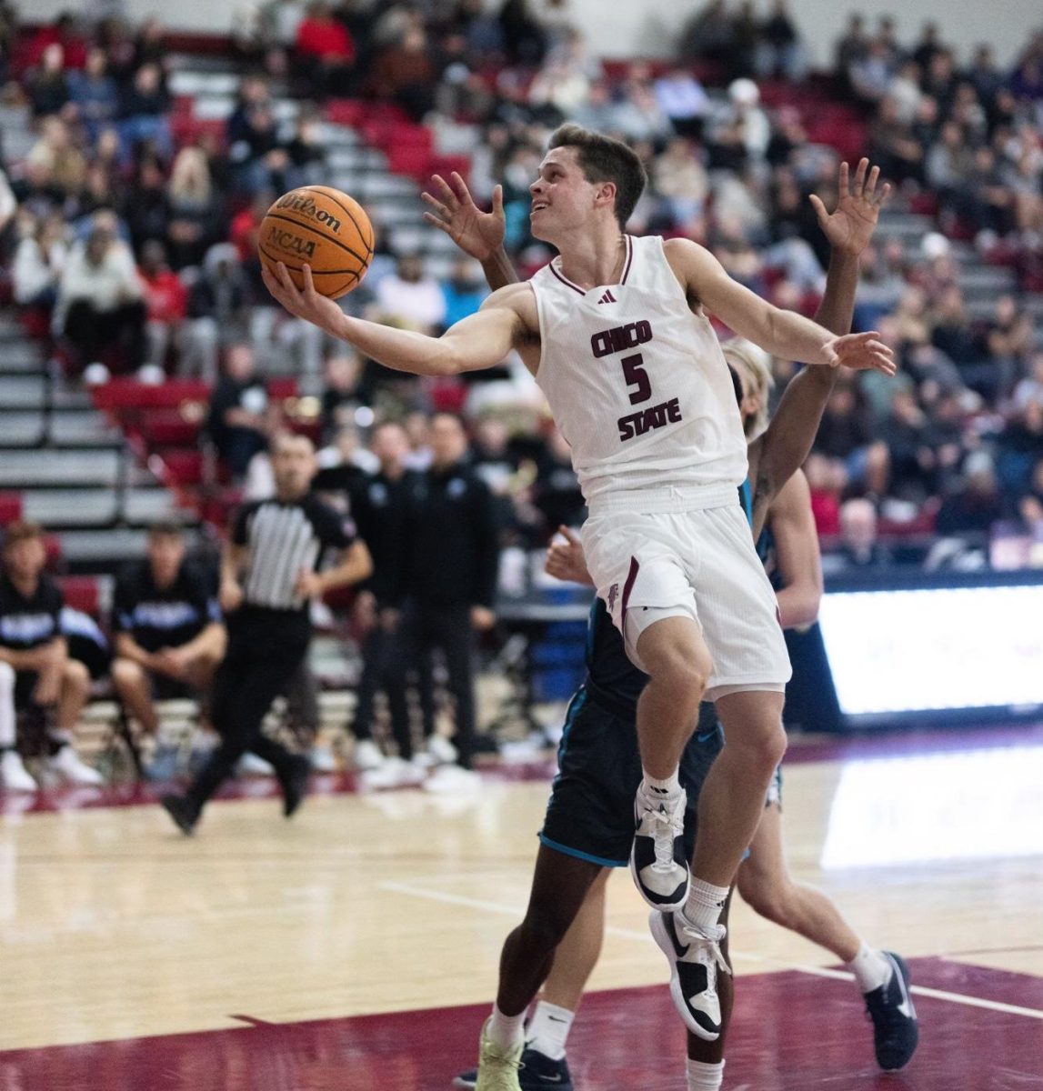 Chico State’s Jojo Murphy going around the Sharks defender with a right-handed layup on the left side of the basket in the first half against the Hawai’i Pacific University Sharks on Nov. 17. Photo taken by Aaron Draper.