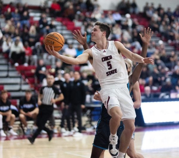 Chico State’s Jojo Murphy going around the Sharks defender with a right-handed layup on the left side of the basket in the first half against the Hawaii Pacific University Sharks on Nov. 17. Photo taken by Aaron Draper.