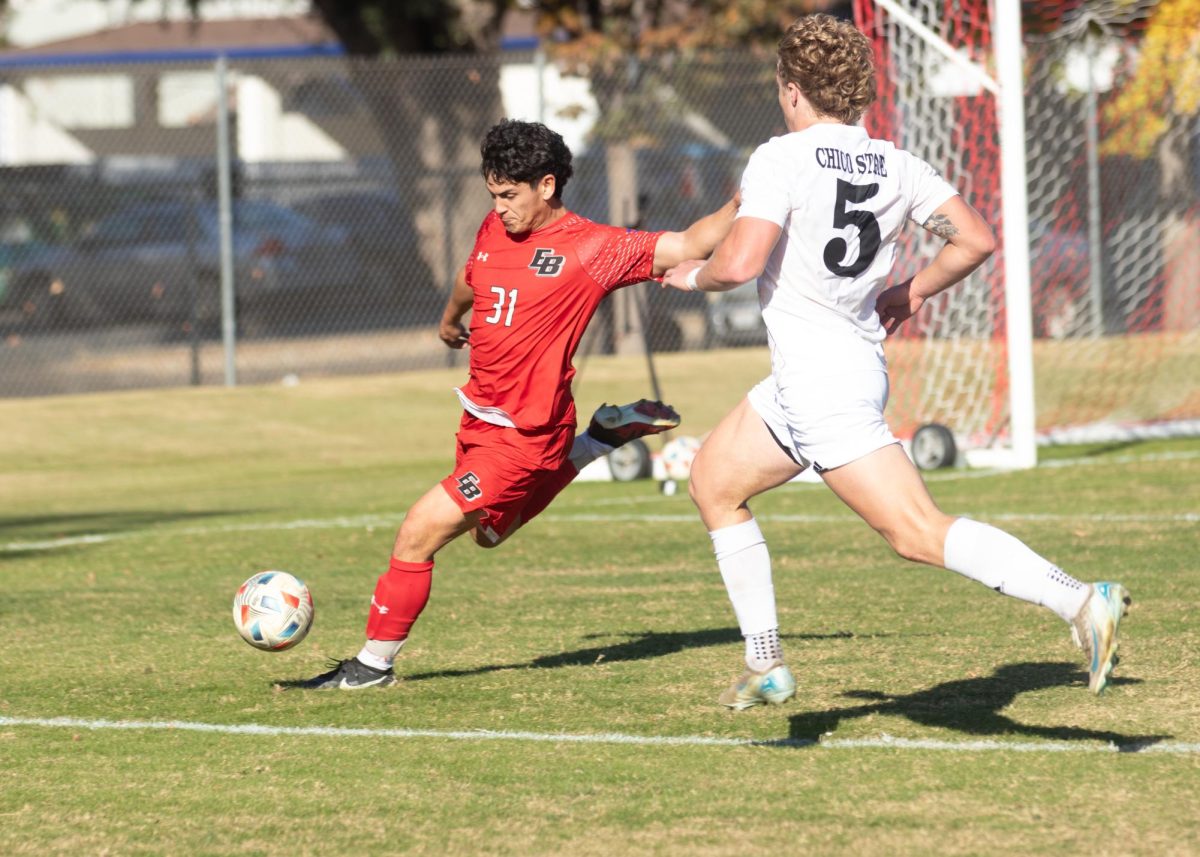 Senior forward Miles Rice rushes to apply pressure as East Bay’s defender James Garlick attempts to clear the ball during the second half of the game at Chico State Sunday, Nov. 10, 2024. 