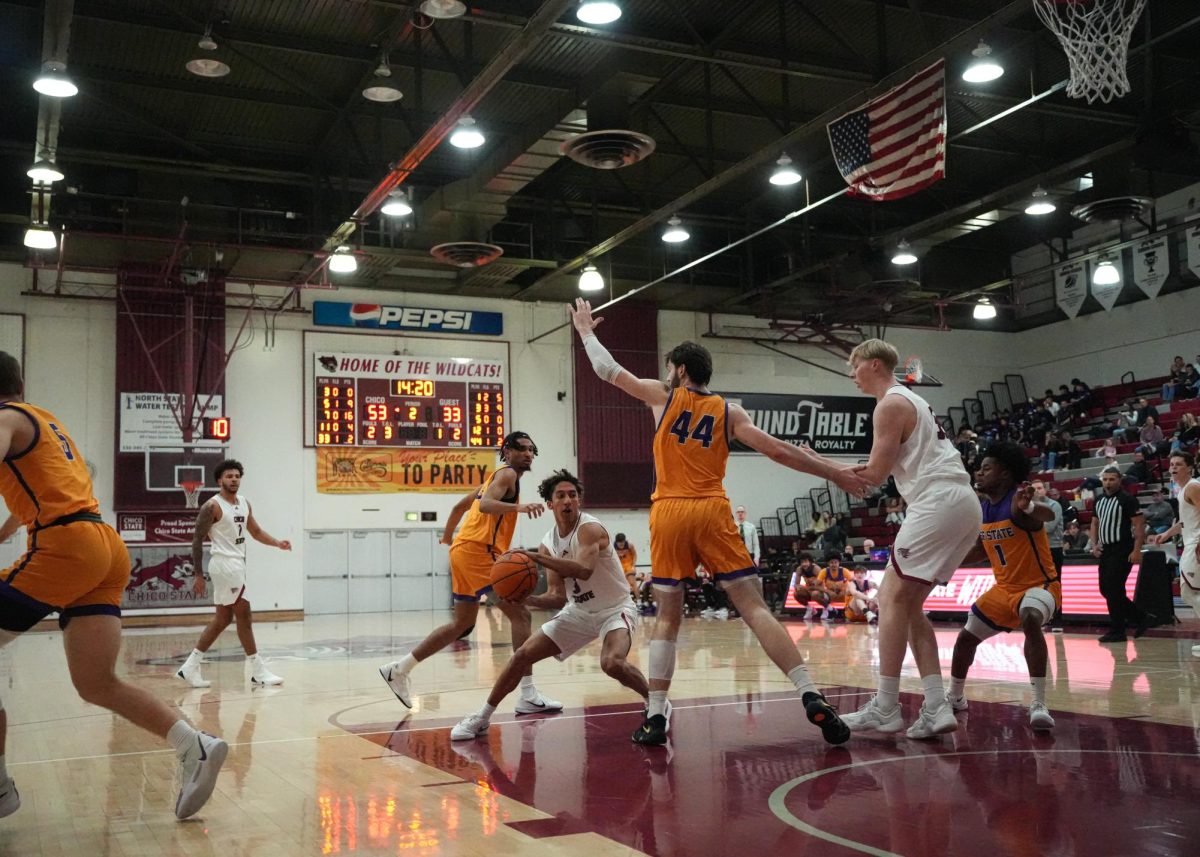 Junior guard Miles Daniels looks to pass the ball while center Pearse Uniacke attempts to block him during the second-half Saturday, Dec. 7, 2024, at Chico State.