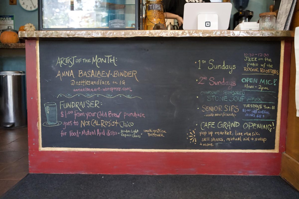 The chalkboard sign beneath the register informs customers of upcoming cafe events and featured artists. Photo taken by Lexi Lynn on Oct. 28, 2025