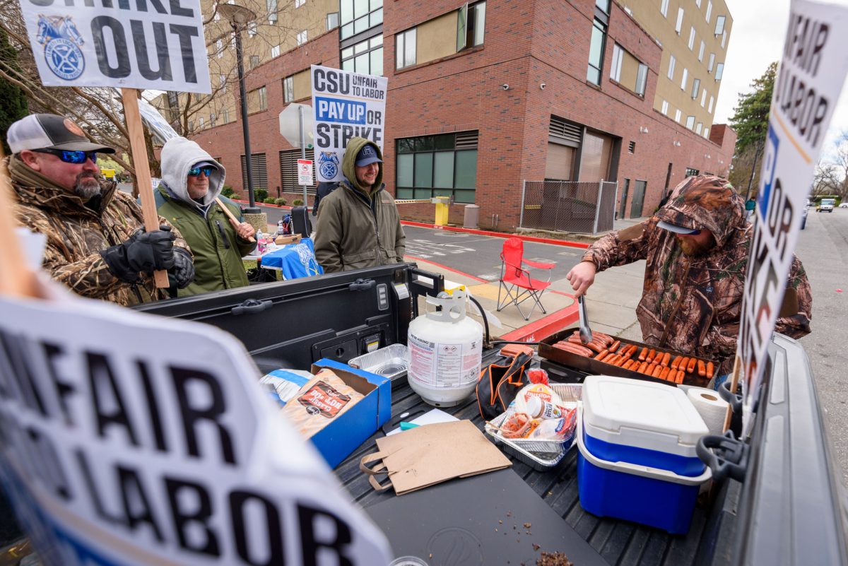 Embracing the warmth before the storm, striking workers grilled hotdogs while chatting to people passing by. Photo taken by Dash Ferrero on Sept. 18, 2026.