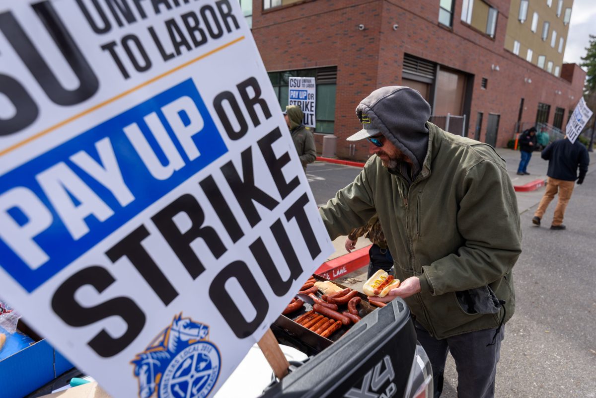 Setting down their picket signs to pickup hotdogs, the Teamsters are picketing behind the dining hall and outside the Student Services Center. Photo taken by Dash Ferrero on Sept. 18, 2026.