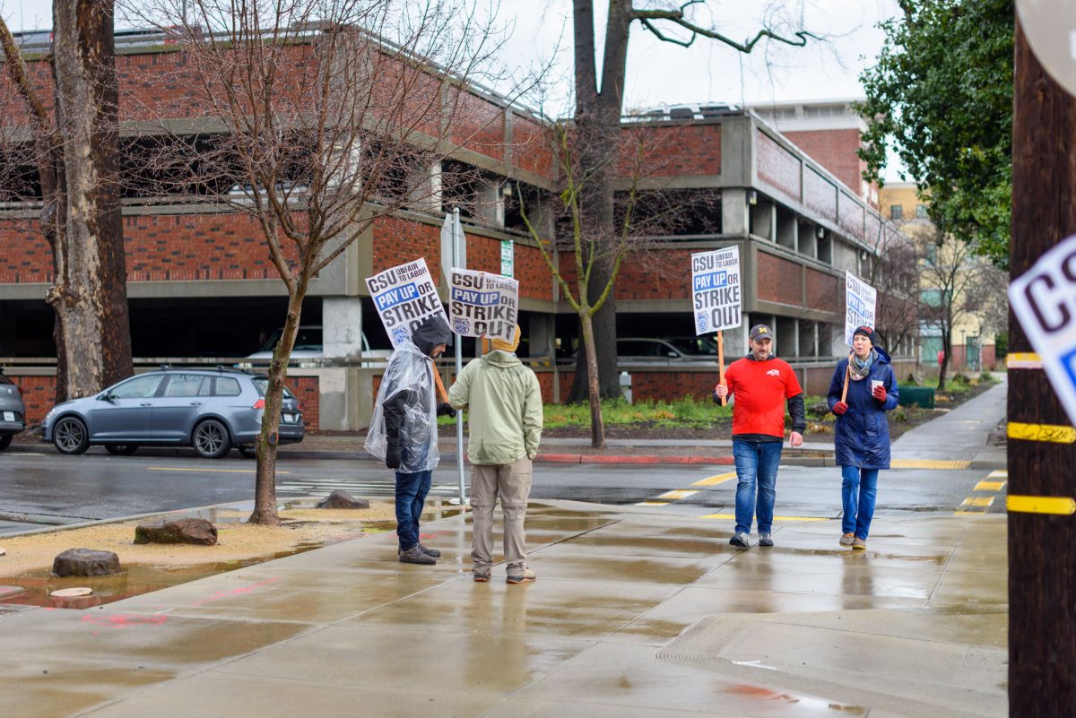 Adam Irish, a political science professor (center right), and Laura Sparks, an English professor (right), picket with members of the striking Teamsters Local 2010 union. "We've got administrators over here on campus making half a million dollars a year," Irish said. "... and these guys are out here in the cold, in the rain, holding signs asking for a fair wage."
Photo taken by Dash Ferrero on Feb. 19, 2026.